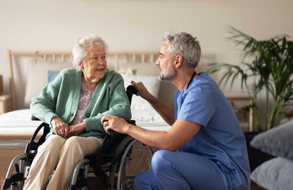 Older adults socializing and playing a table game in a bright, comfortable common area.