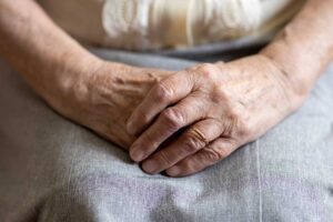 Older adults play a table game together in a bright assisted living community room.